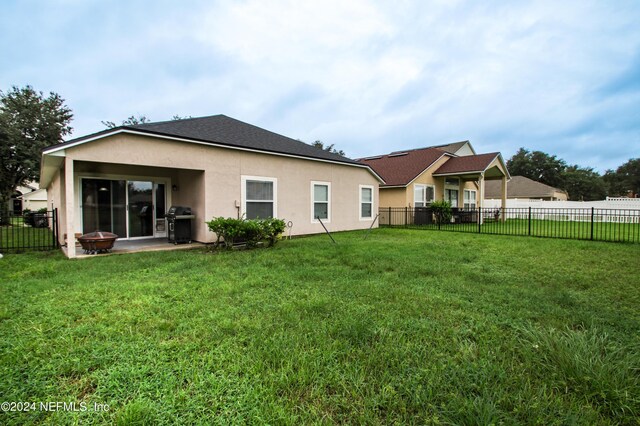 back of property with a lawn and a patio