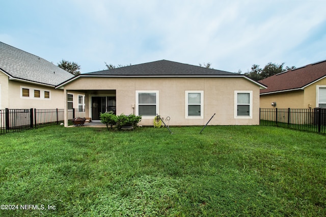 rear view of house with a lawn and a patio