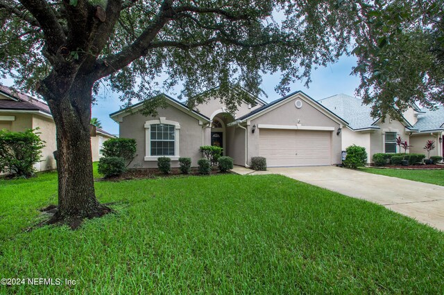 ranch-style house featuring a front lawn and a garage