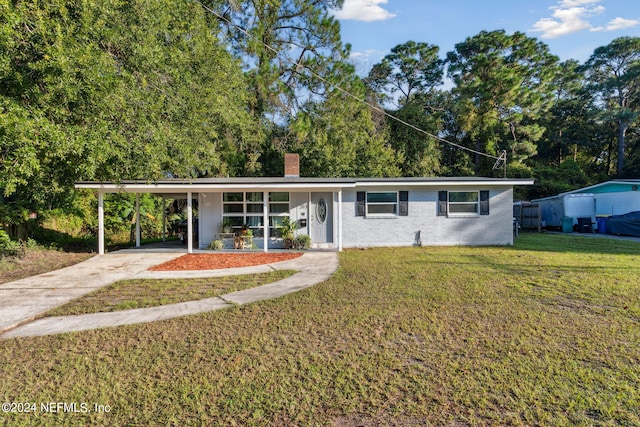 view of front of home with a front yard and a carport