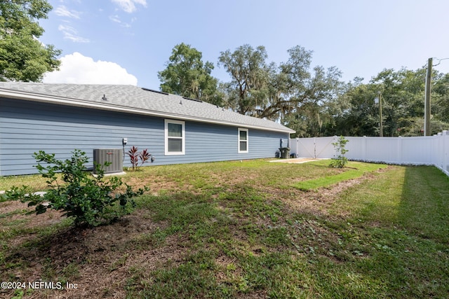 rear view of property featuring cooling unit and a lawn