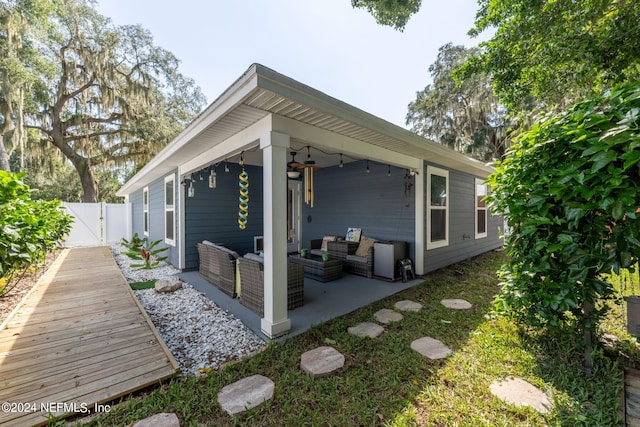 back of house with a patio, outdoor lounge area, and ceiling fan