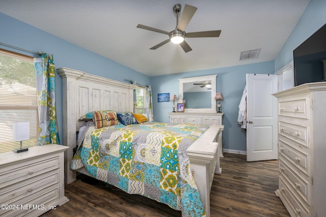 bedroom featuring a textured ceiling, ceiling fan, and dark hardwood / wood-style flooring