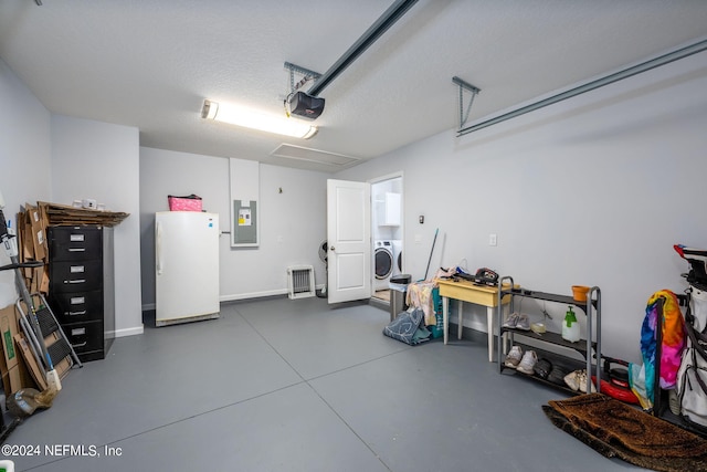 garage featuring a garage door opener, washer / dryer, electric panel, and white fridge