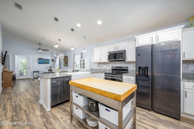 kitchen featuring hanging light fixtures, white cabinetry, stainless steel appliances, light hardwood / wood-style flooring, and sink