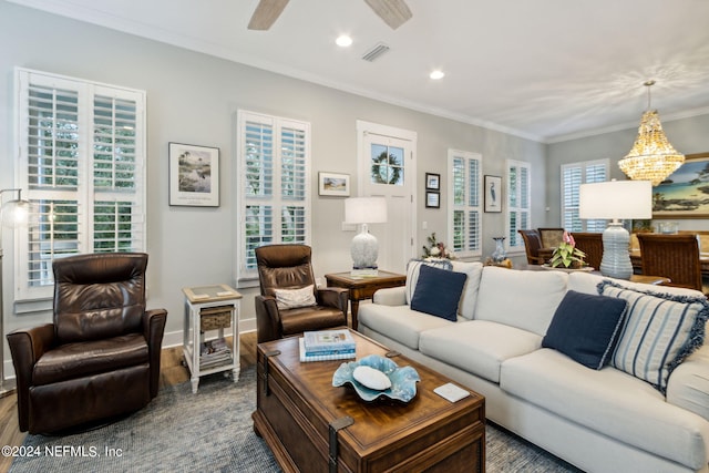 living room with hardwood / wood-style flooring, ceiling fan with notable chandelier, and ornamental molding