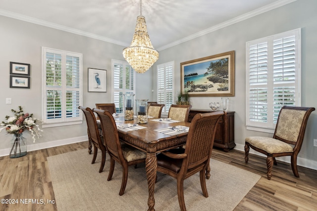 dining space featuring light wood-type flooring, ornamental molding, and an inviting chandelier