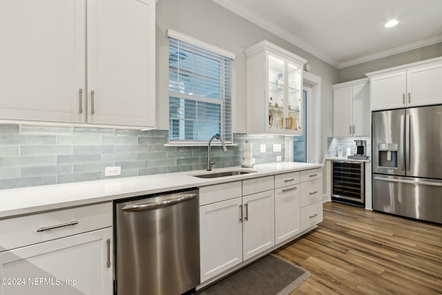 kitchen with white cabinets, beverage cooler, stainless steel appliances, and sink