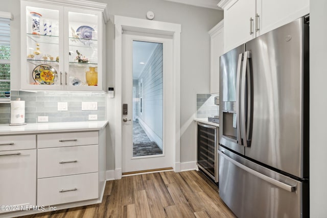 kitchen with stainless steel fridge, white cabinetry, wine cooler, tasteful backsplash, and light hardwood / wood-style flooring