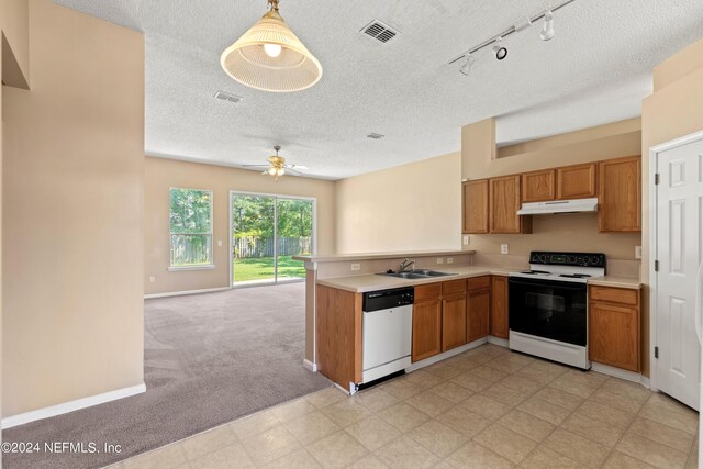 kitchen with ceiling fan, kitchen peninsula, sink, white appliances, and decorative light fixtures