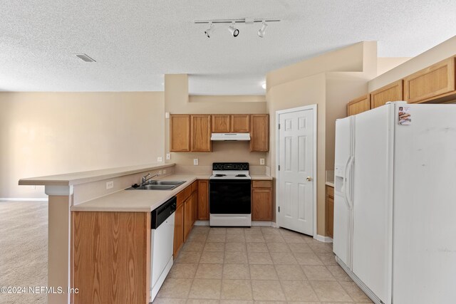 kitchen with kitchen peninsula, sink, white appliances, a textured ceiling, and track lighting