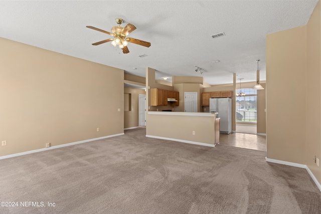 unfurnished living room featuring a textured ceiling, light carpet, and ceiling fan