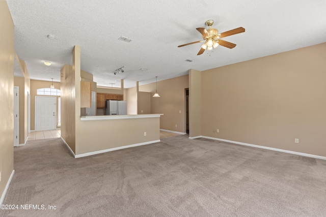 carpeted spare room featuring a textured ceiling and ceiling fan