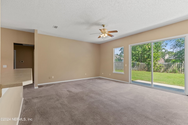 spare room with ceiling fan, a textured ceiling, and carpet flooring