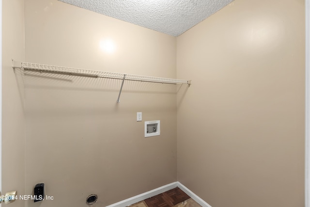 laundry room with washer hookup, a textured ceiling, and parquet flooring