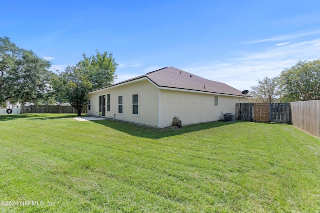 view of side of home featuring a yard and central AC