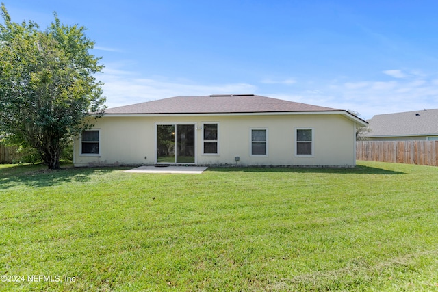 rear view of property with a yard and a patio