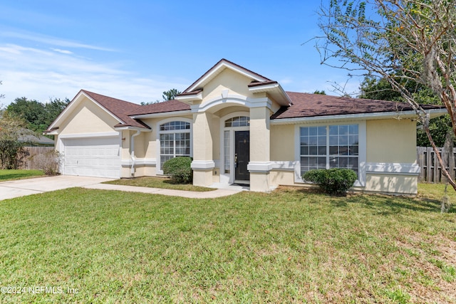 single story home featuring a front lawn and a garage