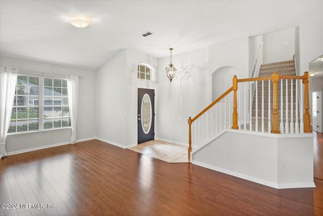 foyer with a textured ceiling, an inviting chandelier, and hardwood / wood-style flooring