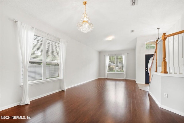 unfurnished living room featuring dark hardwood / wood-style floors and a chandelier