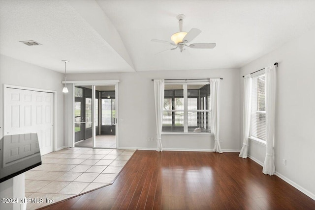 unfurnished room with a wealth of natural light, ceiling fan, and light wood-type flooring