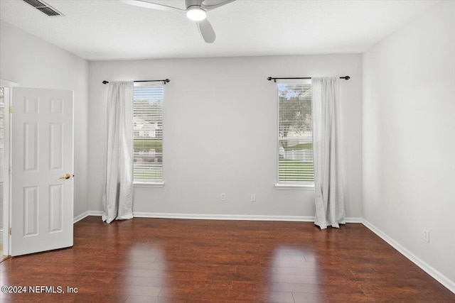 spare room featuring ceiling fan, dark wood-type flooring, and a textured ceiling