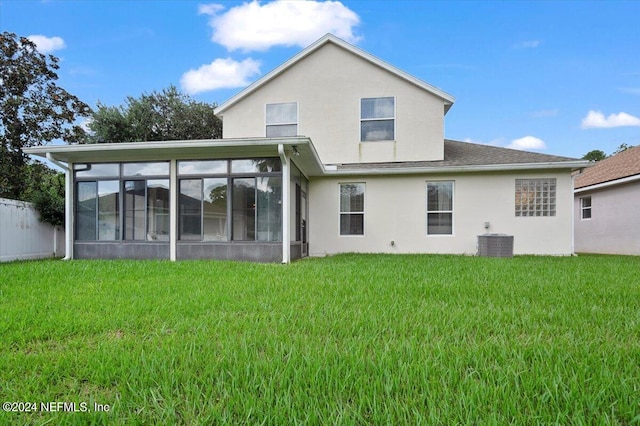 rear view of property with a sunroom, a yard, and central air condition unit