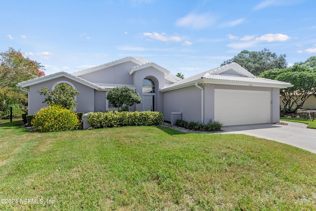 ranch-style house featuring a garage and a front lawn