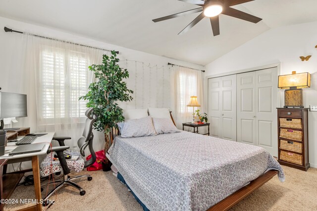 carpeted bedroom with a closet, vaulted ceiling, multiple windows, and ceiling fan