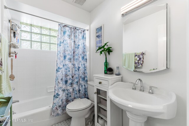 full bathroom with shower / bath combination with curtain, sink, and toilet