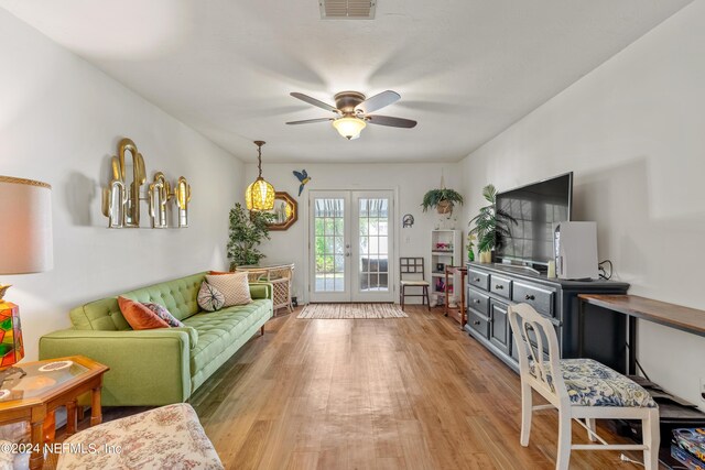 living room featuring light hardwood / wood-style floors, ceiling fan, and french doors