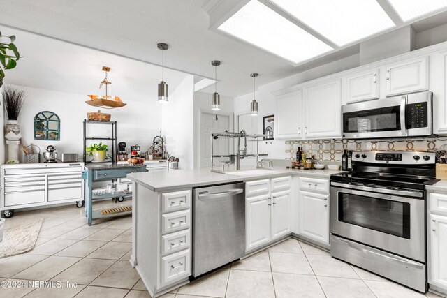 kitchen with pendant lighting, stainless steel appliances, white cabinetry, and kitchen peninsula