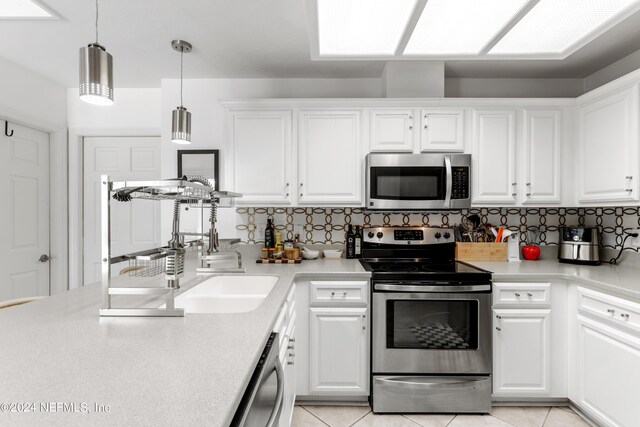 kitchen featuring backsplash, stainless steel appliances, and white cabinets