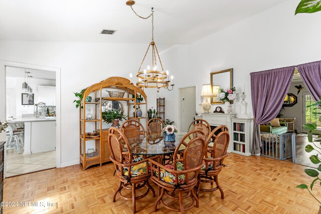 dining room featuring a notable chandelier, high vaulted ceiling, and light parquet floors