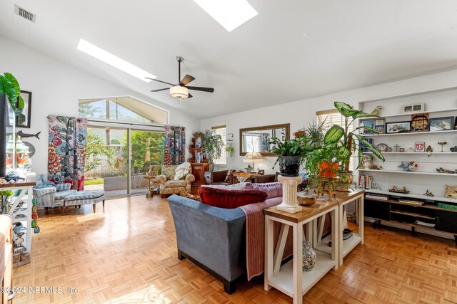 living room with light parquet floors, ceiling fan, a skylight, and high vaulted ceiling