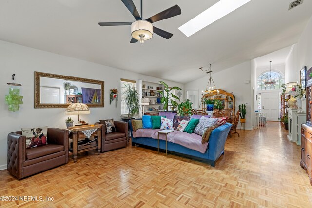 living room with ceiling fan with notable chandelier, lofted ceiling with skylight, and light parquet floors