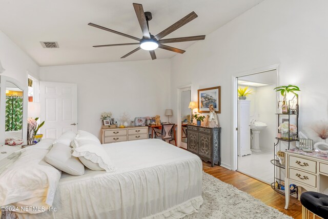 bedroom with light hardwood / wood-style flooring, connected bathroom, lofted ceiling, and ceiling fan