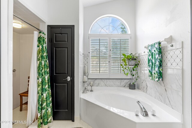 bathroom with independent shower and bath, lofted ceiling, and tile patterned flooring