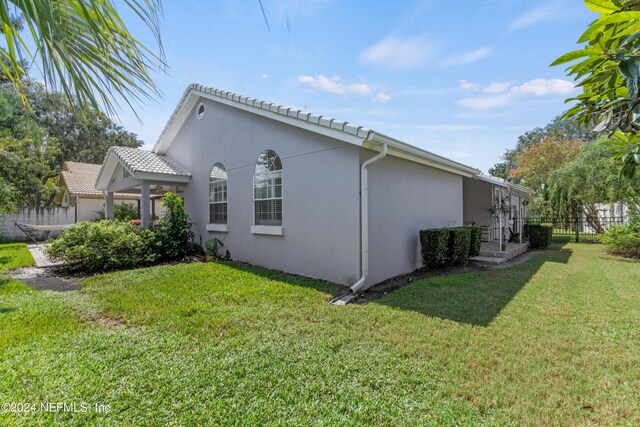 view of property exterior with a lawn