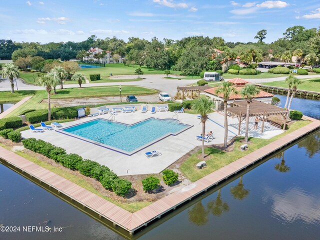 view of pool with a lawn, a patio, and a water view