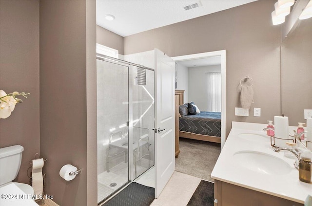 bathroom featuring vanity, toilet, tile patterned floors, and an enclosed shower