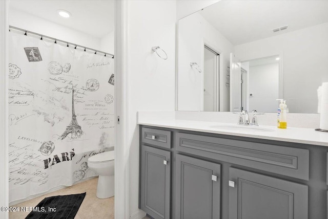 bathroom featuring curtained shower, vanity, and toilet