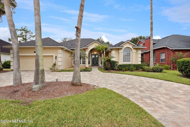 ranch-style home with a garage and a front lawn