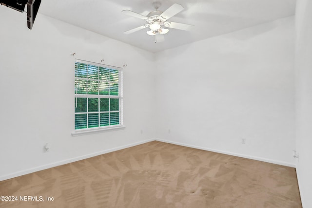 carpeted spare room featuring ceiling fan