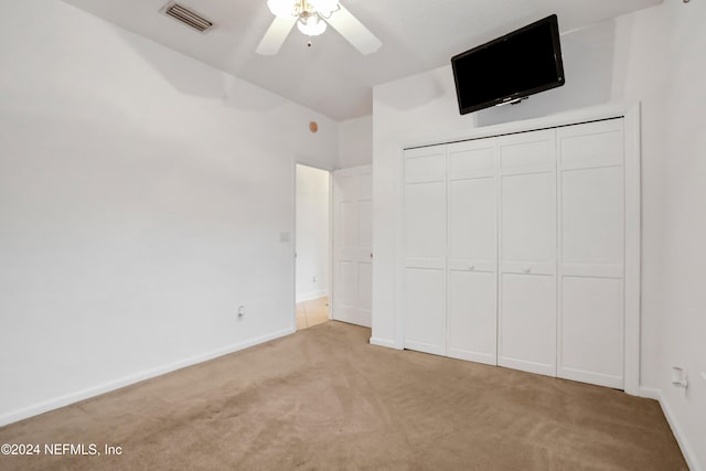 unfurnished bedroom with a closet, ceiling fan, and light colored carpet