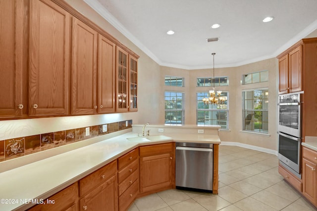 kitchen with an inviting chandelier, ornamental molding, light tile patterned flooring, decorative light fixtures, and stainless steel appliances