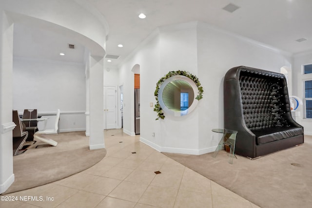 carpeted foyer with ornamental molding