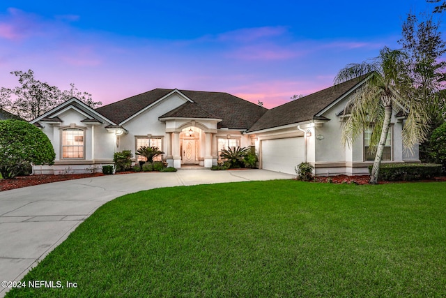 view of front of house featuring a garage and a lawn