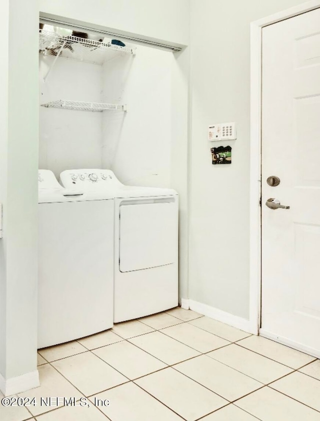 laundry room featuring washing machine and dryer and light tile patterned floors