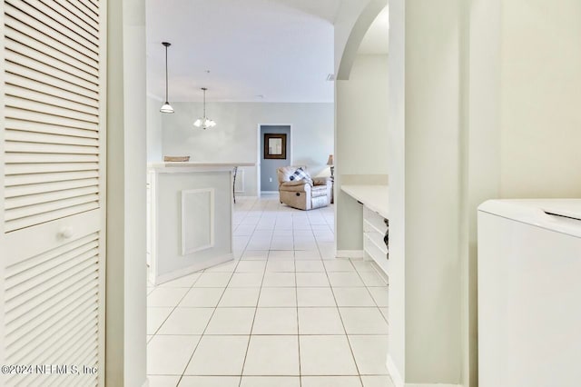 corridor featuring washer / clothes dryer and light tile patterned flooring